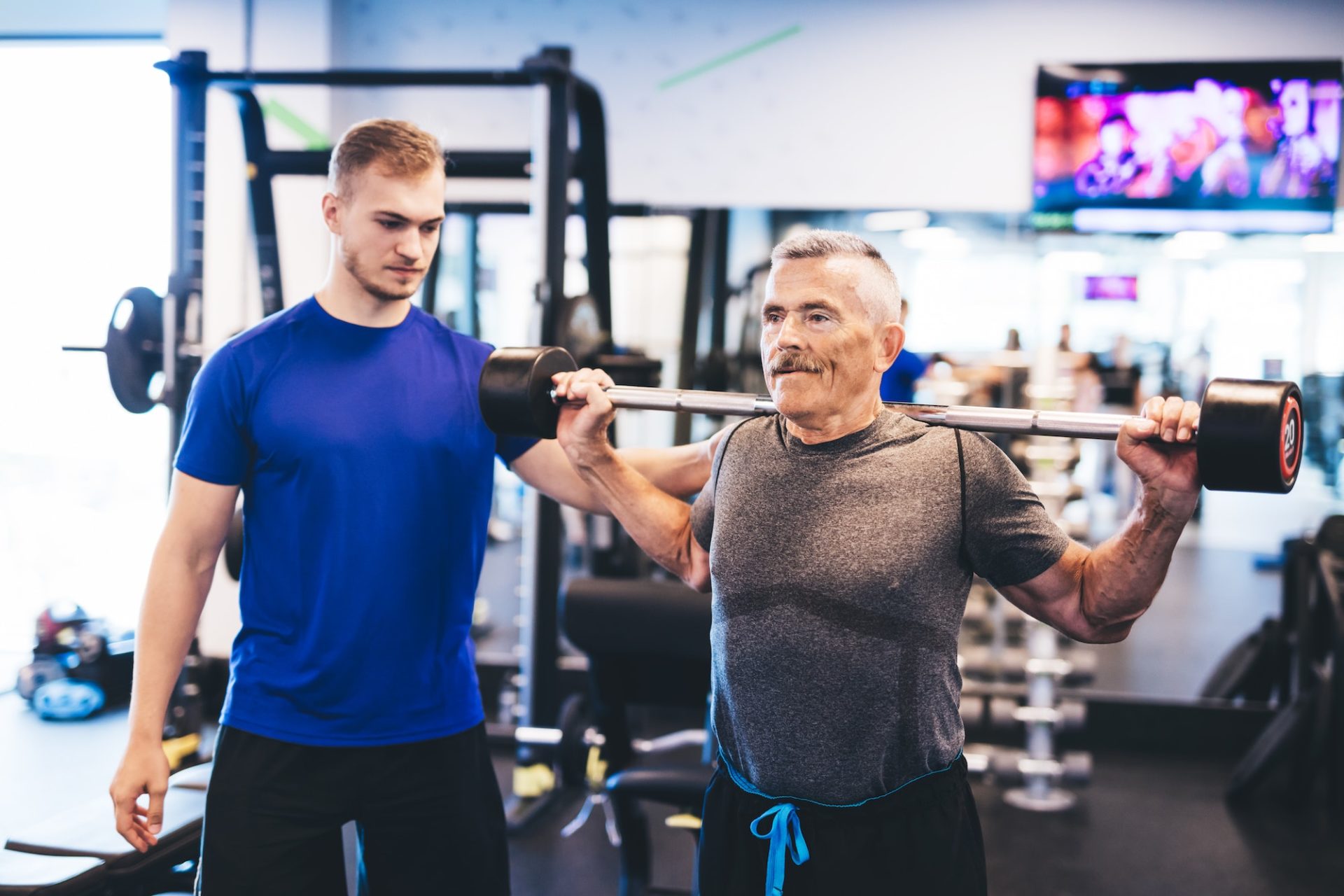 older-man-assisting-senior-man-at-the-gym--e1677564441929.jpg